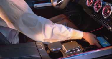 Person reaching for their phone in the front center console