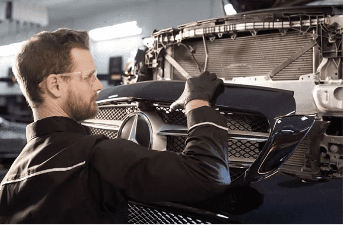 A Benzel-Busch technician repairing the front end of a Mercedes-Benz