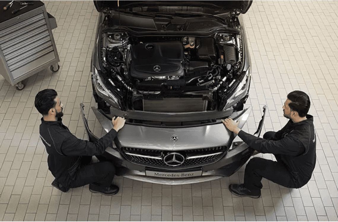 Two Benzel-Busch technicians reassembling the front end of a Mercedes-Benz