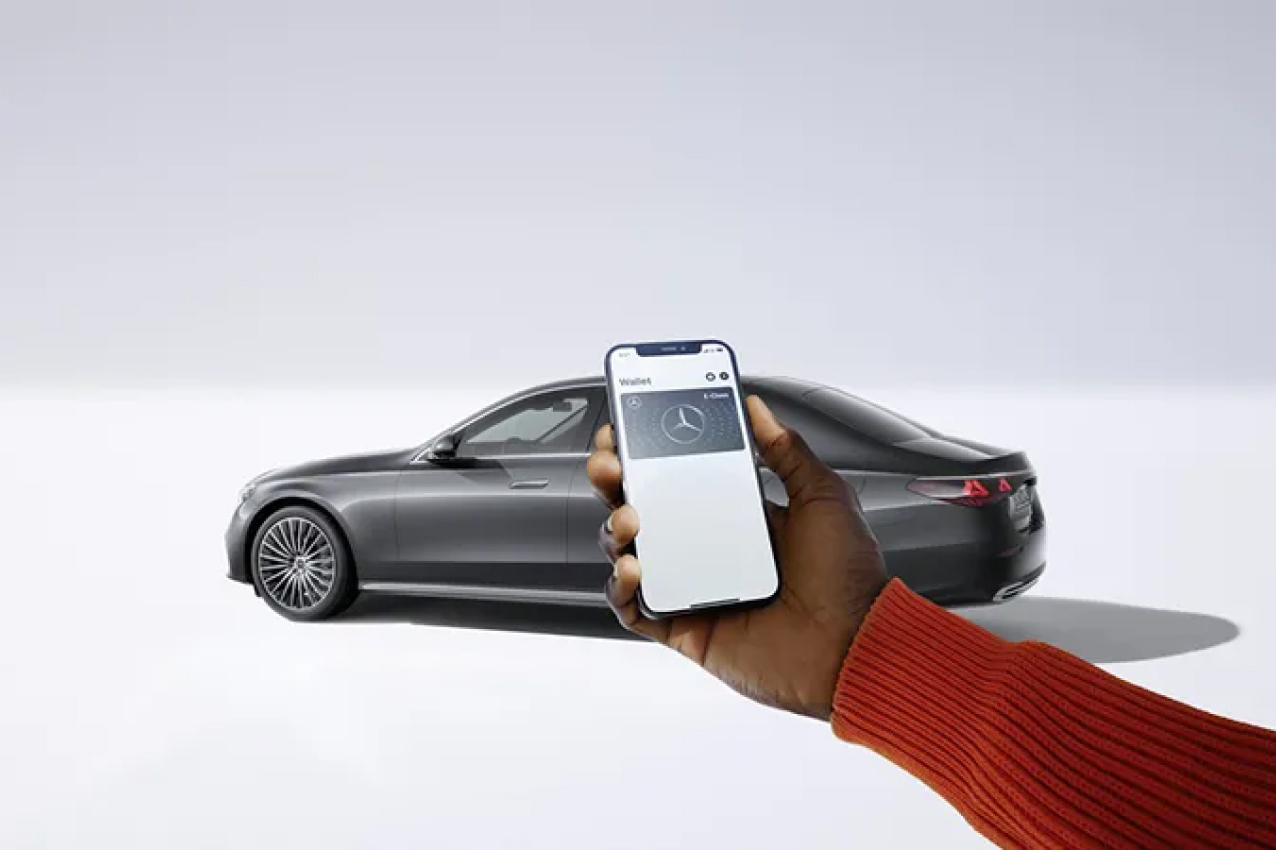 Smartphone held up in front of a Mercedes-Benz vehicle