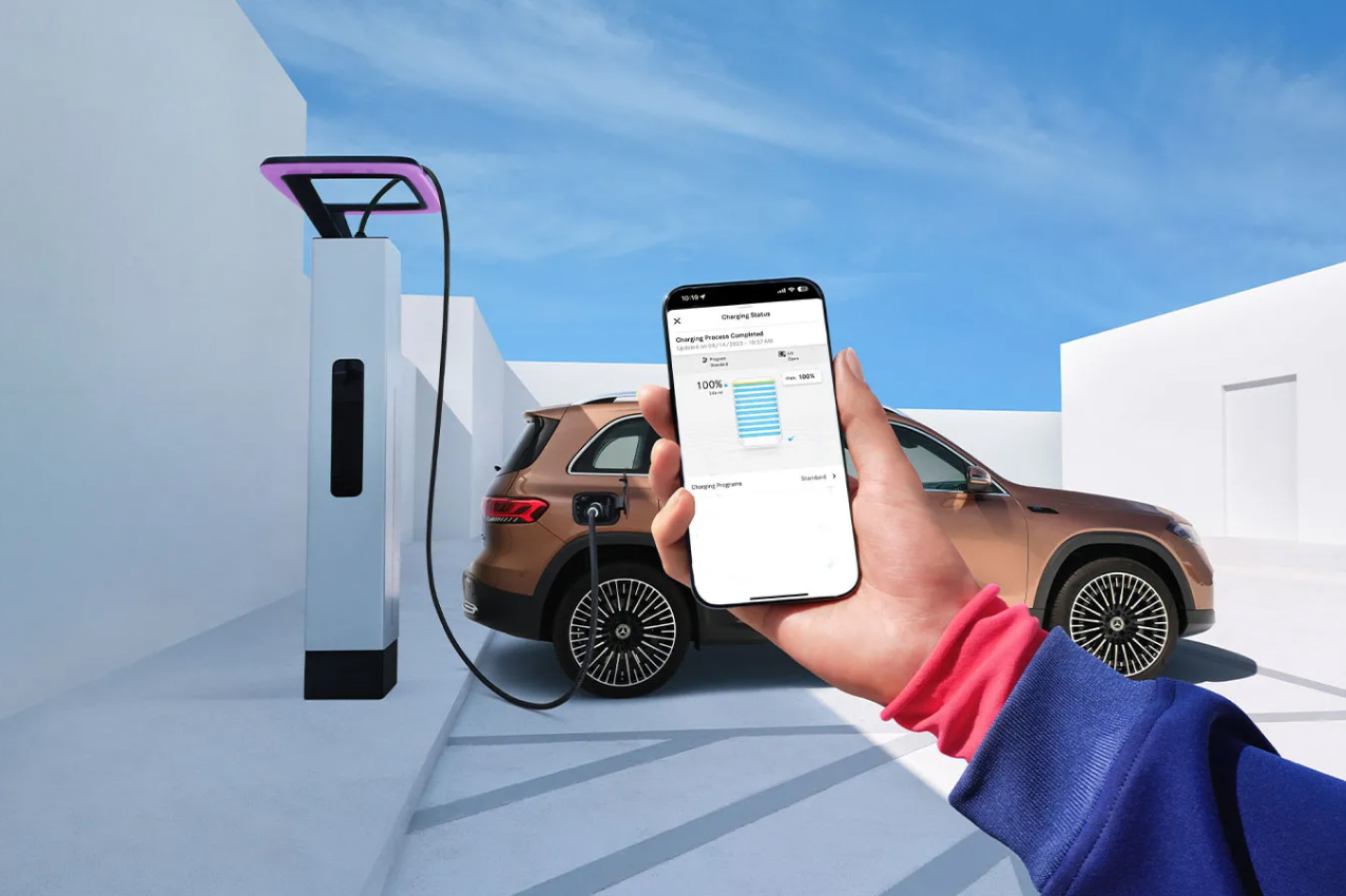 Hand holding a smartphone in front of a charging station